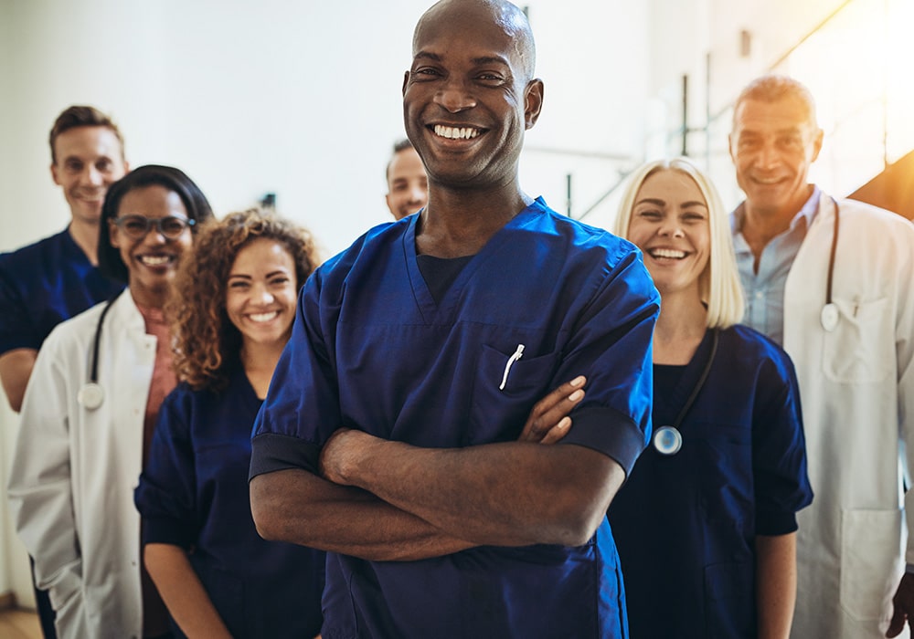 A group of doctors and nurses in a group smiling.
